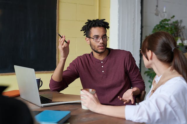 Two people having a conversation at a table.