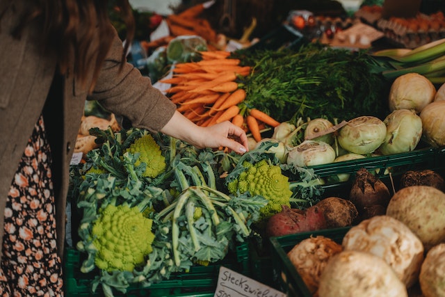 a-person-looking-at-vegetables-at-a-farmers-market