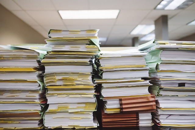 Several large stacks of folders filled with papers.